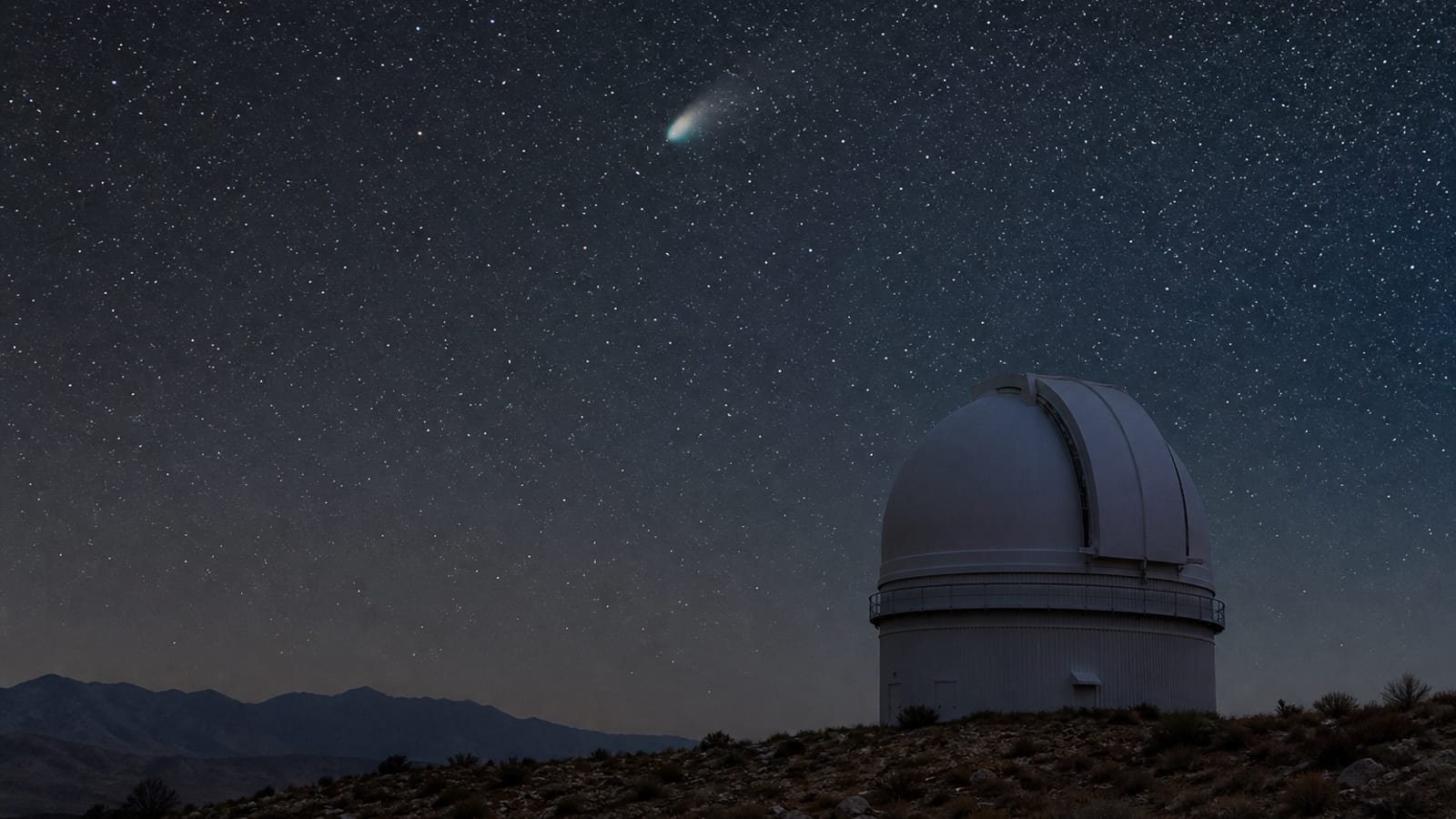 A faint comet in the night sky above an observatory dome