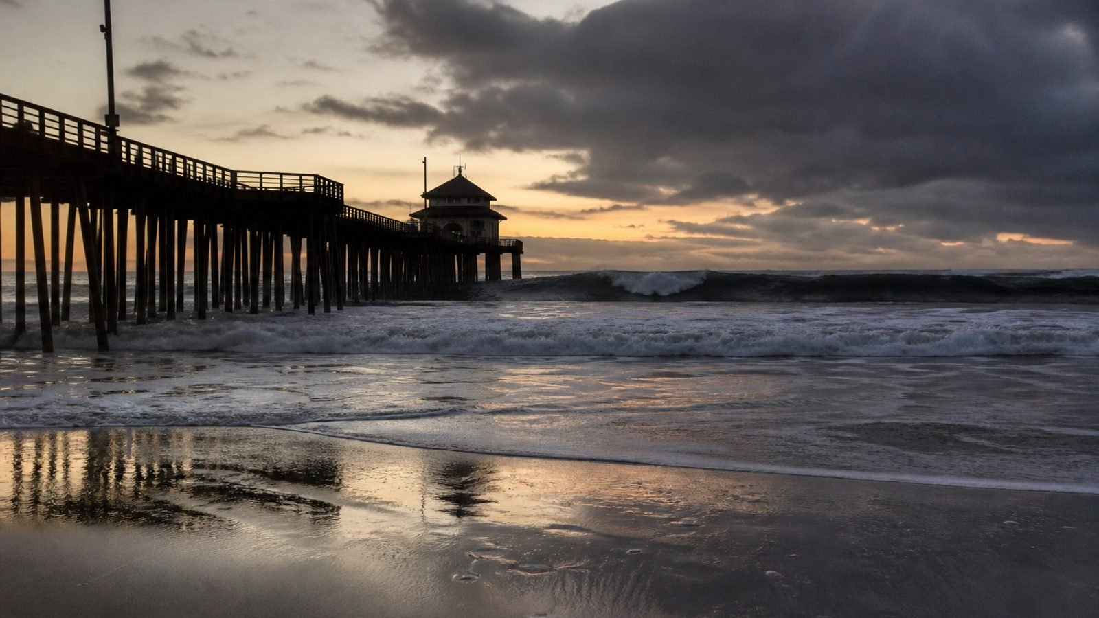 A Southern California pier at dusk with huge south swell