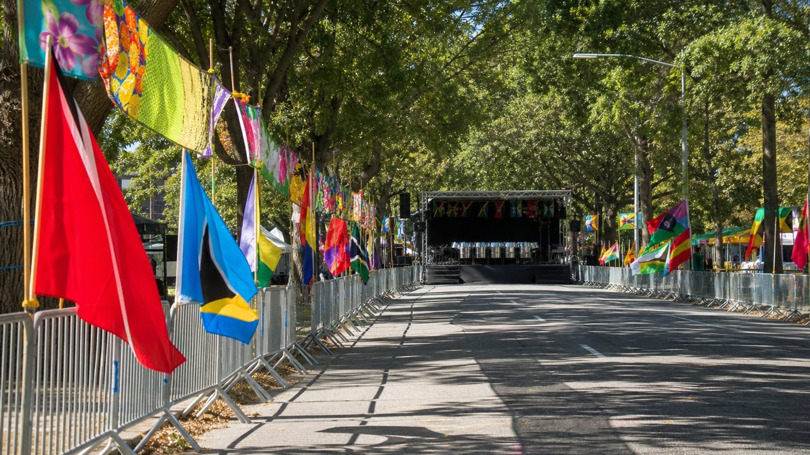 A tree-lined urban parkway dressed for a Caribbean carnival