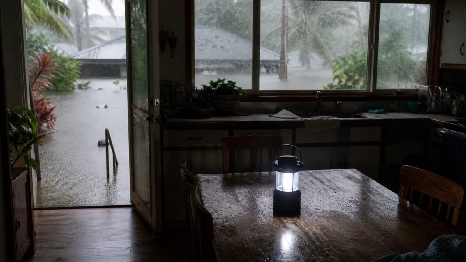 A Hawaiian kitchen in daylight with the lights off and a battery lantern on the table