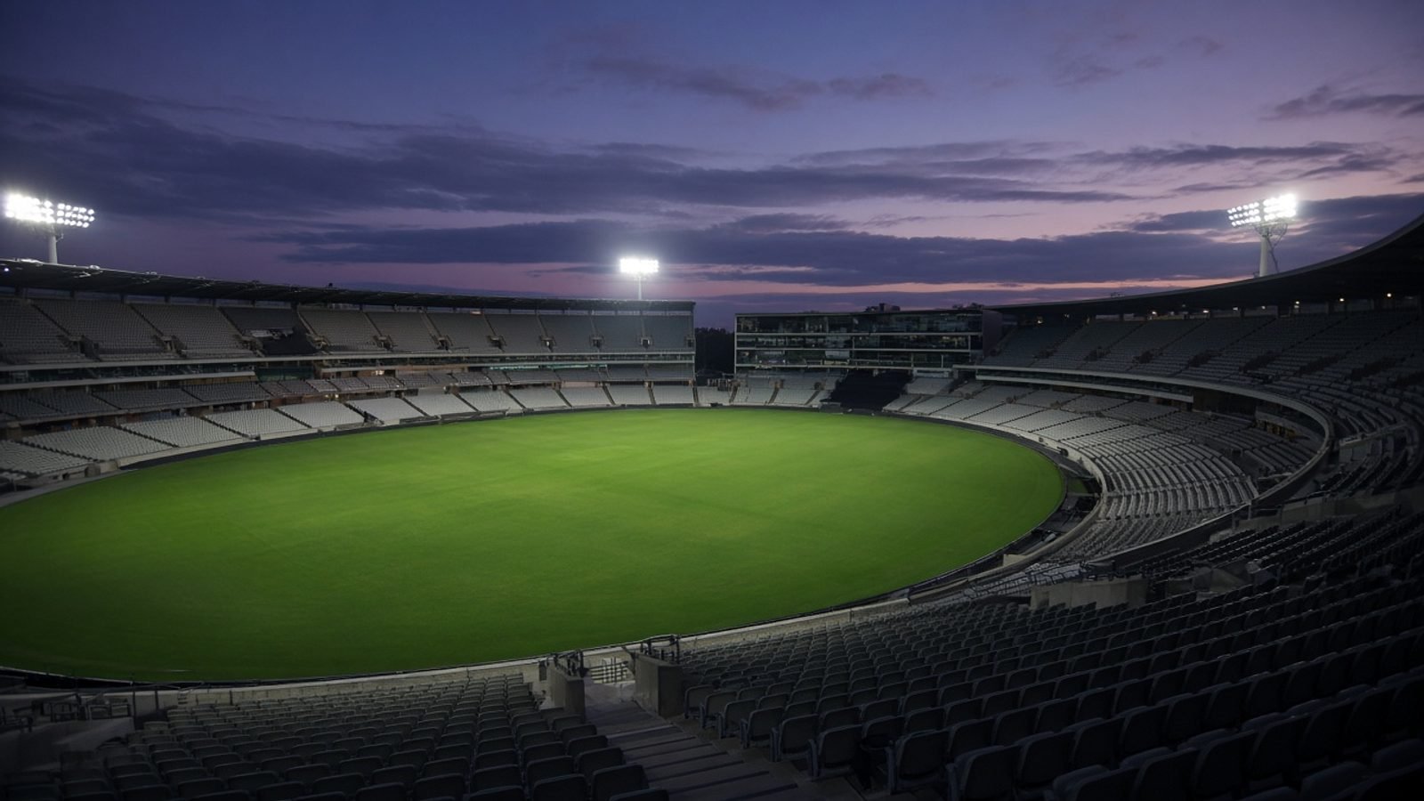 An empty floodlit stadium at twilight before kickoff