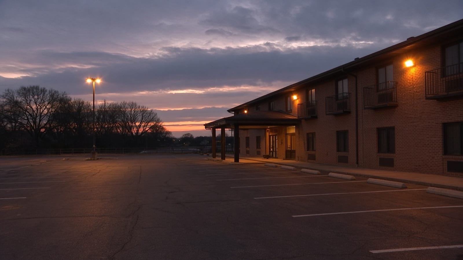 An empty chain hotel parking lot at dusk