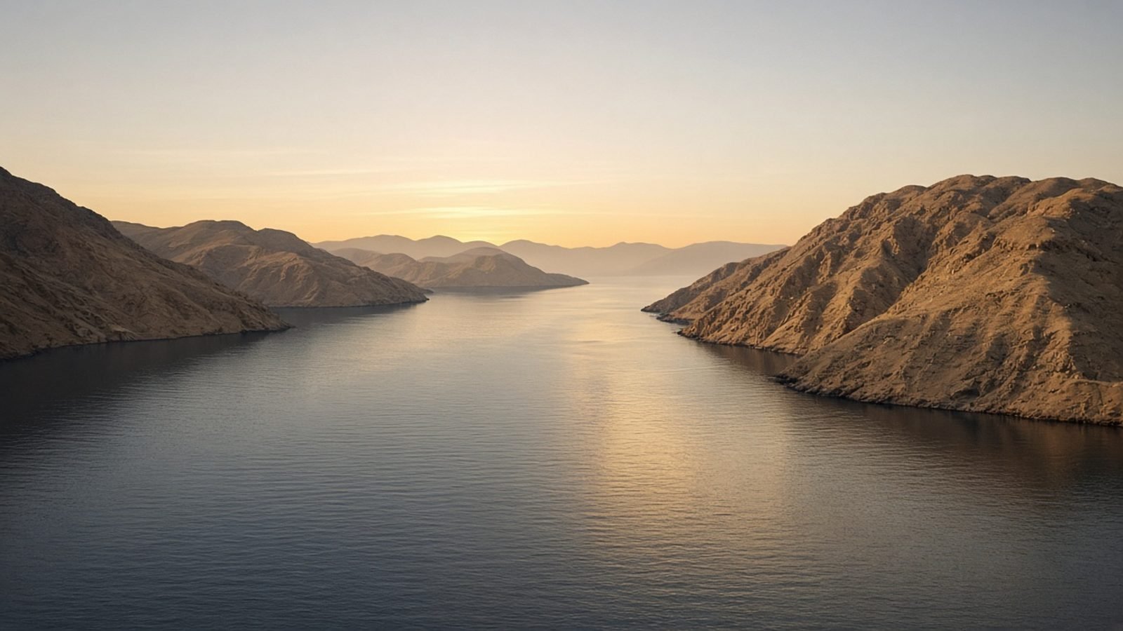 A tanker-free gulf strait at dawn with arid cliffs