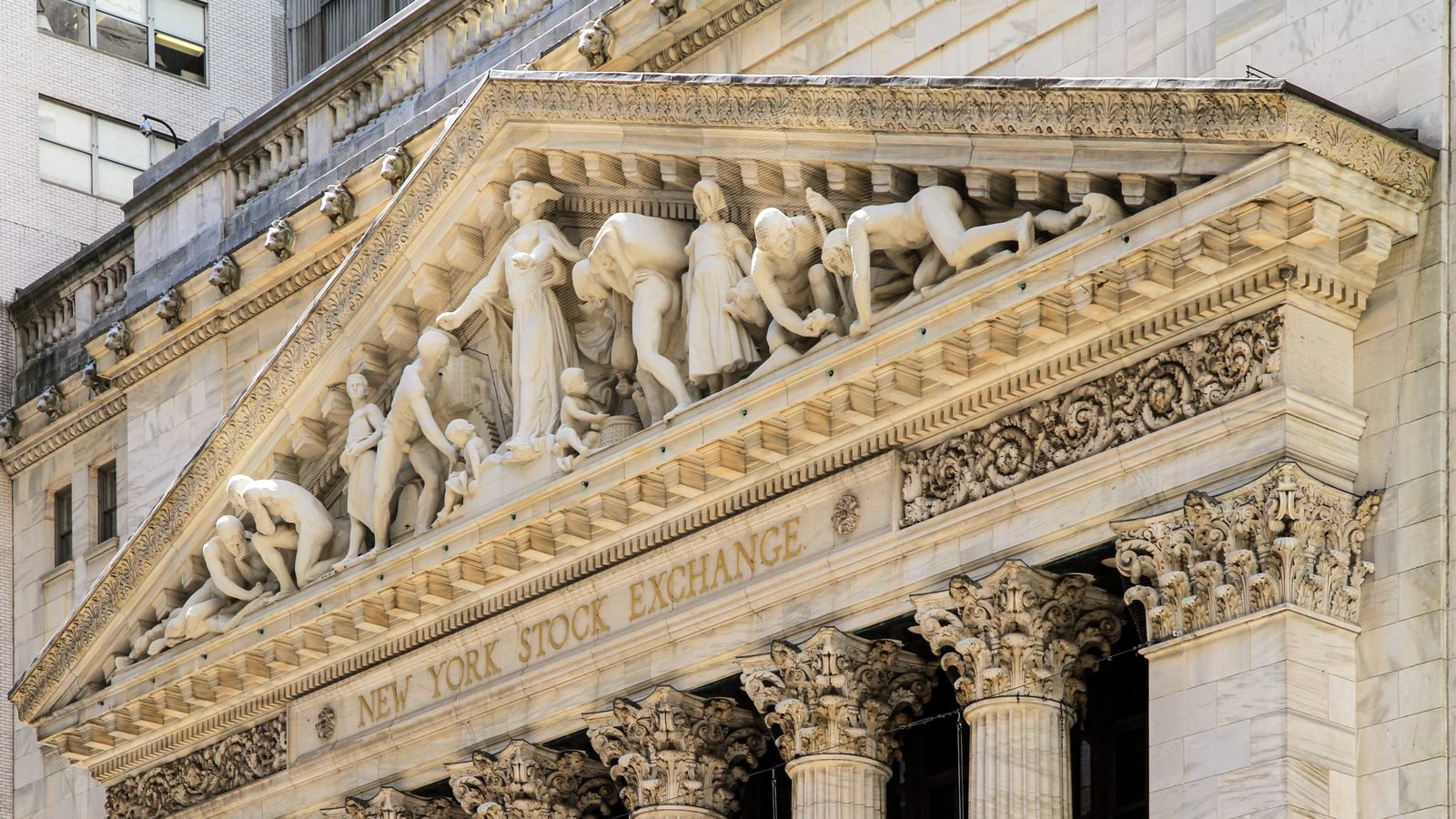 The New York Stock Exchange pediment and gold lettering above the columns. Photograph by Ingfbruno, CC BY-SA.