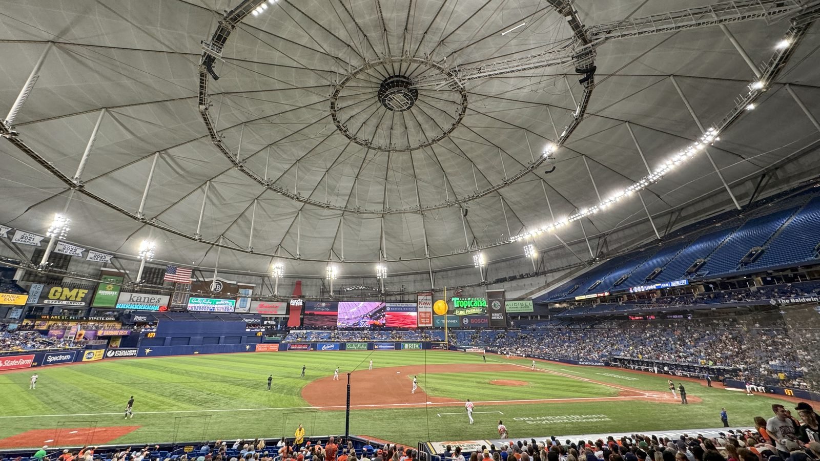 The interior of Tropicana Field in St. Petersburg, including the domed roof, the field, and the stands. Photograph by Quintin Soloviev, CC BY.