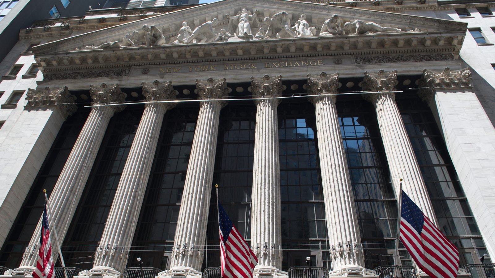 The New York Stock Exchange Broad Street facade, with columns, pediment, and American flags. Photograph by 颐园居, CC BY-SA.